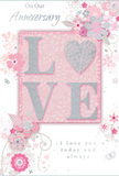 The anniversary card in this image exudes a gentle, romantic charm, much like a pastel arrangement prepared for a riverside home in Greenwich. At its heart, the word LOVE rises in textured, glitter-touched letters, each stroke dusted with soft silver that adds a refined shimmer. The letters lie upon a blush pink panel with a subtle pearlescent glow, lending the central motif a sense of soft illumination. Radiating around this focal point is a delicate composition of stylised flowers and leaves, drawn in blush pink, pearly white, and light grey tones. The blooms are finely outlined with some petals washed in gentle shading, others highlighted with slender traces of metallic silver, evoking the layered petals and airy foliage of a romantic bouquet designed for an anniversary in East Greenwich or near Greenwich Market. The background is a smooth field of pale pink, calm and unobtrusive, allowing the floral artwork to breathe. Between the flowers, graceful swirls, tiny hearts, and faint suggestions of butterflies provide movement and a playful sense of celebration while keeping the overall look elegant. Flowing script beneath the central word expresses anniversary wishes and the promise of enduring love, perfectly matched to the tenderness conveyed by the design. The composition feels balanced and serene, like a thoughtful card chosen to accompany fresh anniversary flowers delivered across Greenwich, capturing both the beauty of the occasion and the depth of shared affection.